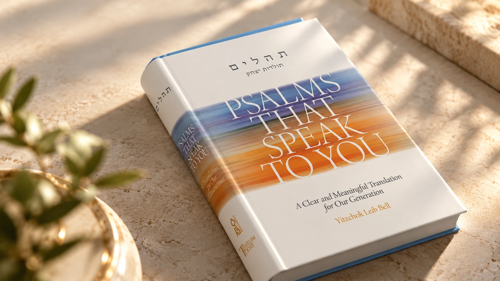 Psalms That Speak to You hardback lying on warm stone beside an olive branch, in dappled sunlight